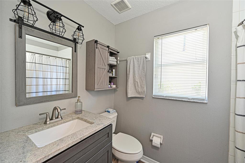12709 Nightshade Place Lakewood Ranch, FL 34202 - Photo 30 of 53 a bathroom with a granite countertop sink toilet a mirror and window