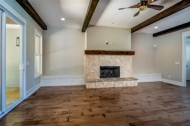 a view of empty room with wooden floor and fireplace