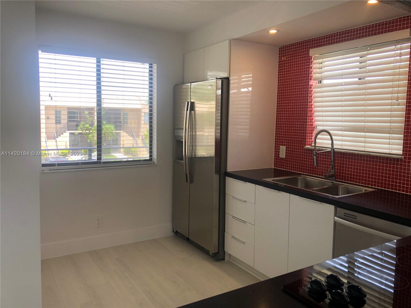 330 Racquet Club Road, Unit 201 Weston, FL 33326 - Photo 12 of 43 a kitchen with granite countertop a sink and a refrigerator
