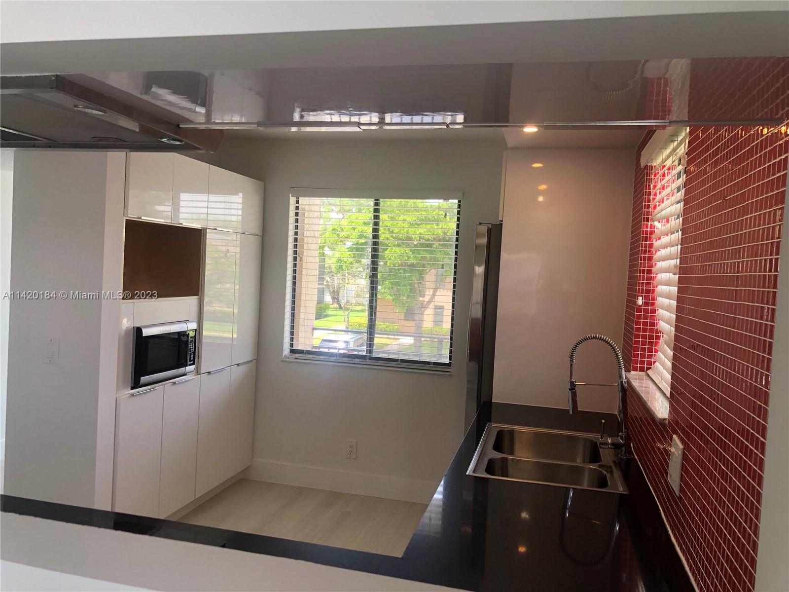 330 Racquet Club Road, Unit 201 Weston, FL 33326 - Photo 13 of 43 a kitchen with granite countertop a stove and a microwave