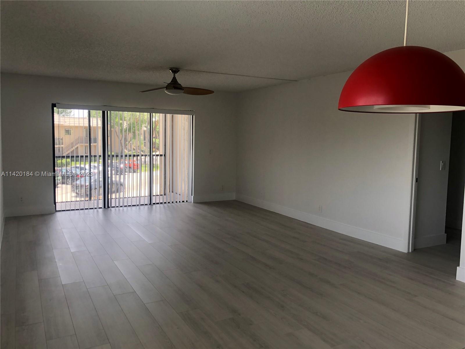 330 Racquet Club Road, Unit 201 Weston, FL 33326 - Photo 17 of 43 a view of an empty room with wooden floor and a window