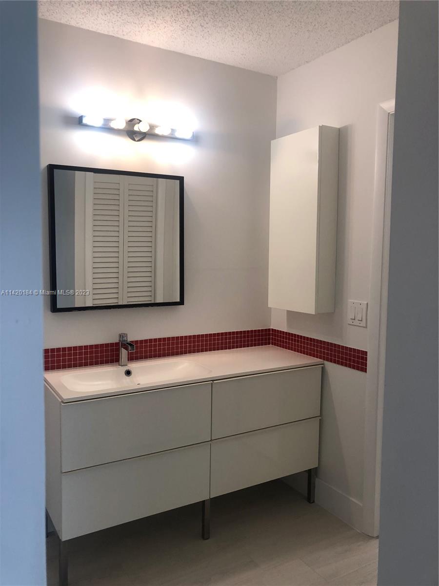 330 Racquet Club Road, Unit 201 Weston, FL 33326 - Photo 28 of 43 a bathroom with a sink and a mirror