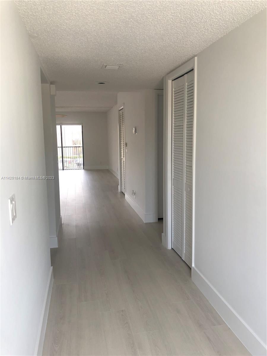 330 Racquet Club Road, Unit 201 Weston, FL 33326 - Photo 6 of 43 an empty room with windows and entrance to other room