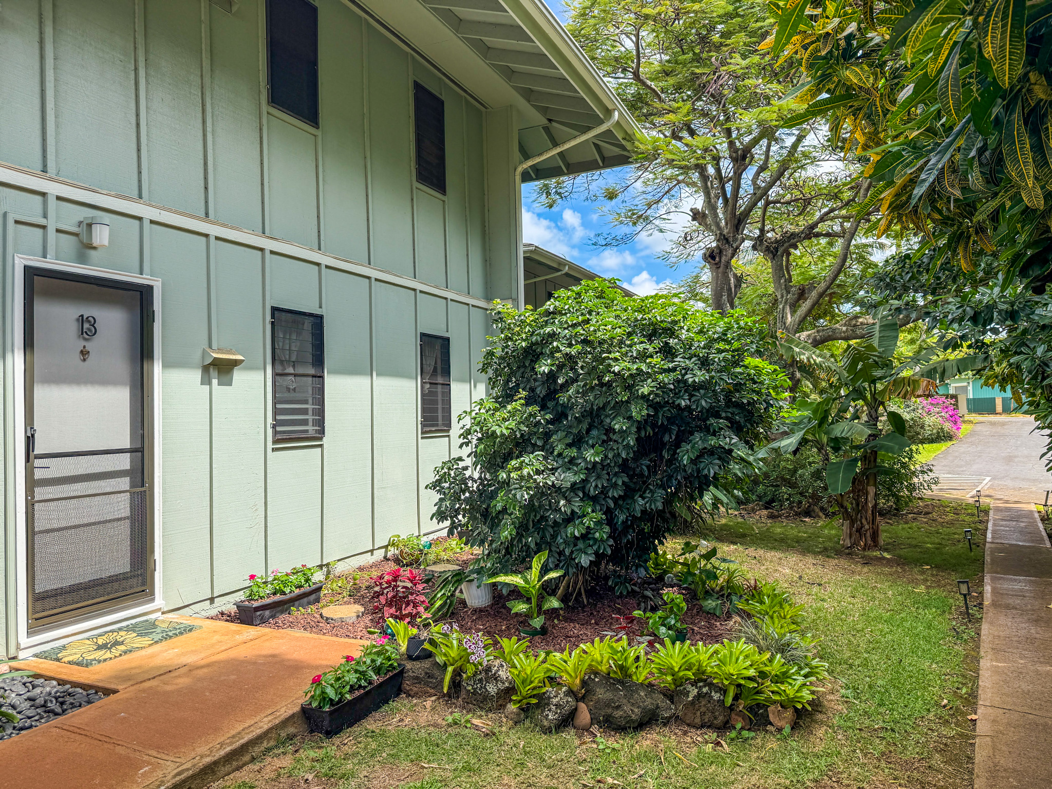 3057 Poipu Road, Unit D13 Koloa, HI 96756 - Photo 15 of 18 a view of backyard with potted plants and a large tree