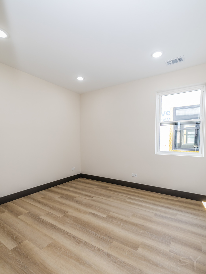 5643 South Prairie Avenue, Unit 1 Chicago, IL 60637 - Photo 13 of 15 a view of an empty room with wooden floor and a window