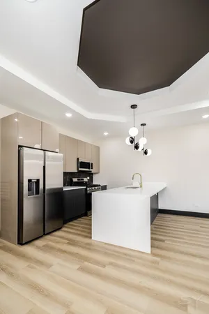 a large white kitchen with a refrigerator a stove top oven a sink and dishwasher