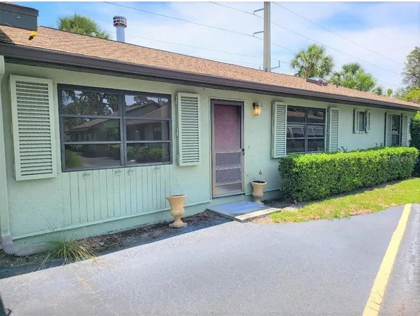 a front view of a house with a yard and potted plants