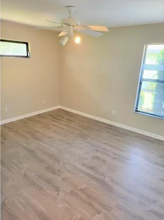 an empty room with a window and wooden floor