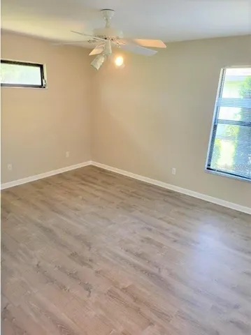 an empty room with a window and wooden floor
