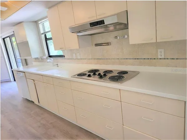 a kitchen with granite countertop white cabinets and sink