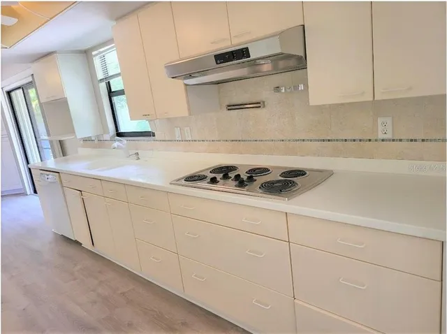 a kitchen with granite countertop white cabinets and sink