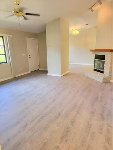 an empty room with windows and fireplace