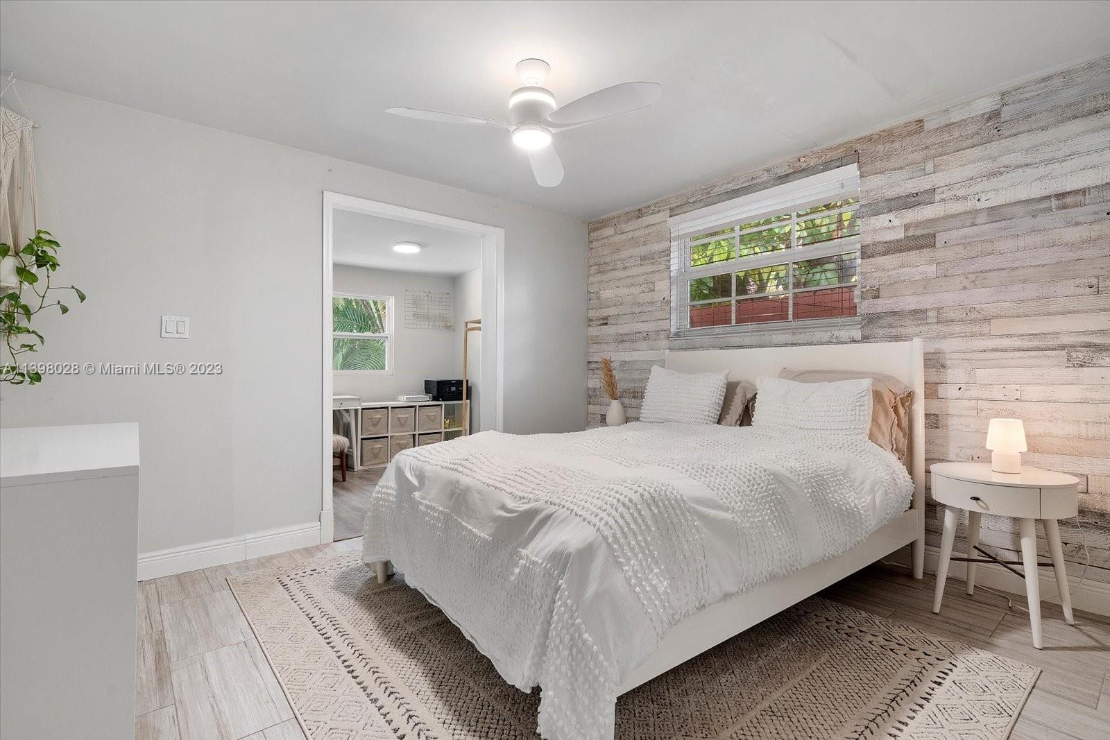 443 Northeast 71st Street Miami, FL 33138 - Photo 14 of 22 a bedroom with a bed and a chandelier