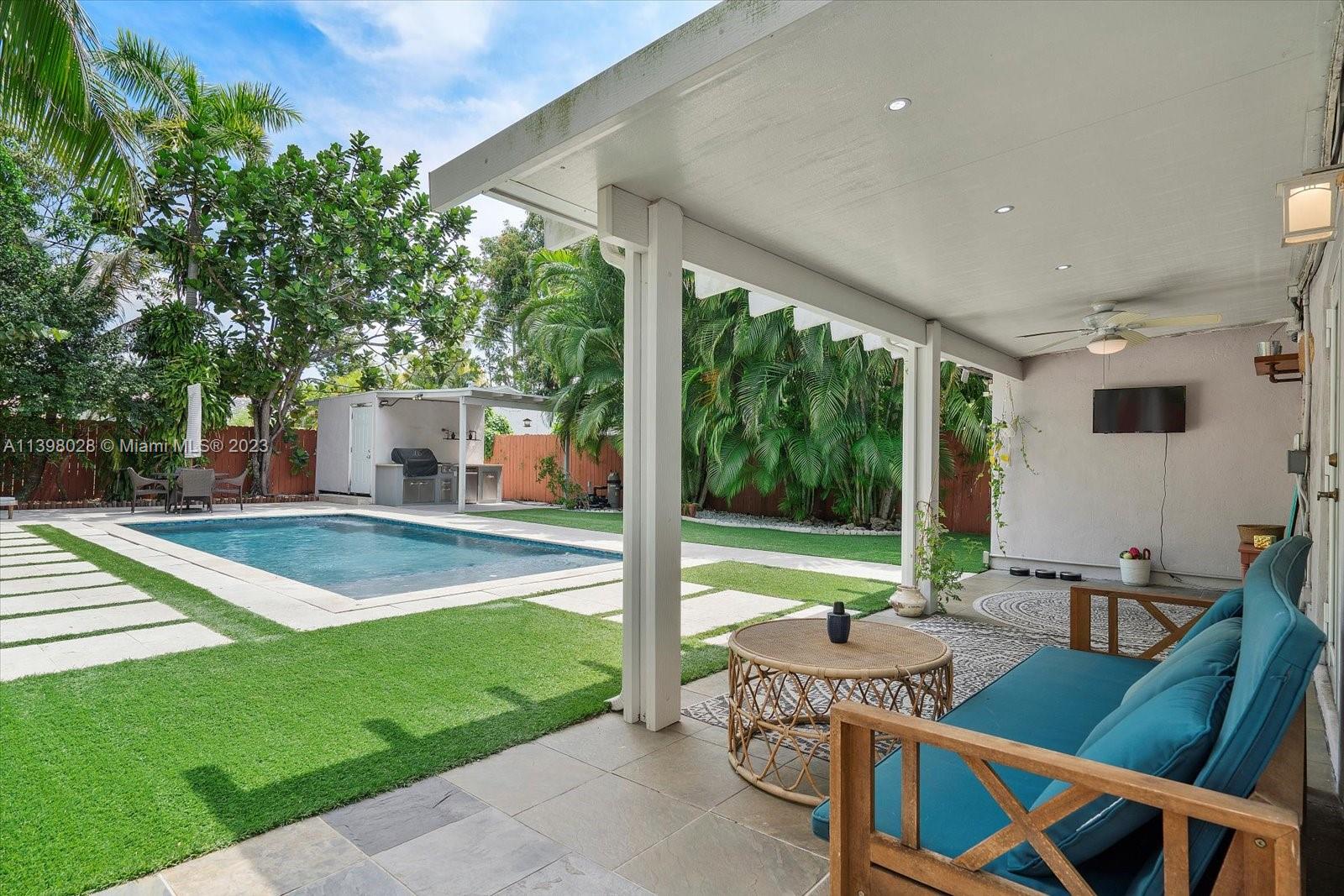 443 Northeast 71st Street Miami, FL 33138 - Photo 17 of 22 a view of a patio with table and chairs potted plants with wooden floor and fence