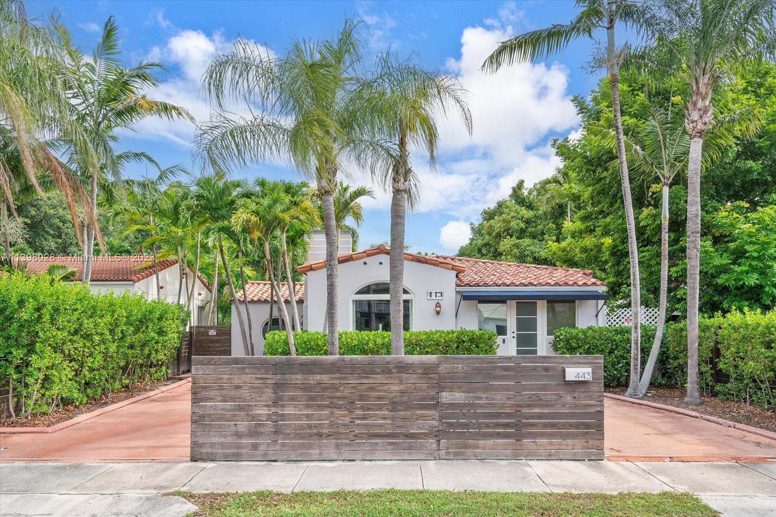 443 Northeast 71st Street Miami, FL 33138 - Photo 2 of 22 a front view of a house with a yard and a garage