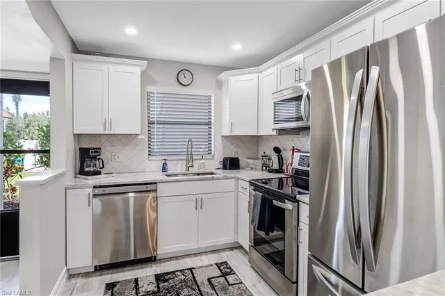 a kitchen with stainless steel appliances granite countertop a refrigerator sink and stove