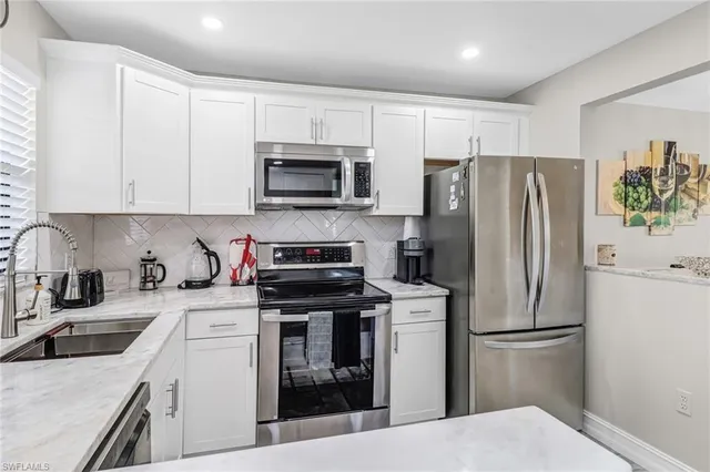 a kitchen with cabinets stainless steel appliances and a sink