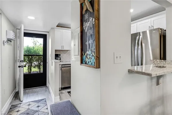 a view of kitchen with stainless steel appliances granite countertop a refrigerator and a sink