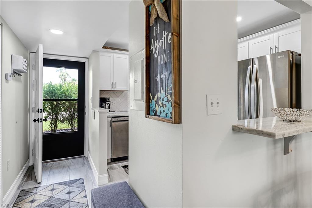 4166 27th Court Southwest, Unit 104 Naples, FL 34116 - Photo 14 of 25 a view of kitchen with stainless steel appliances granite countertop a refrigerator and a sink