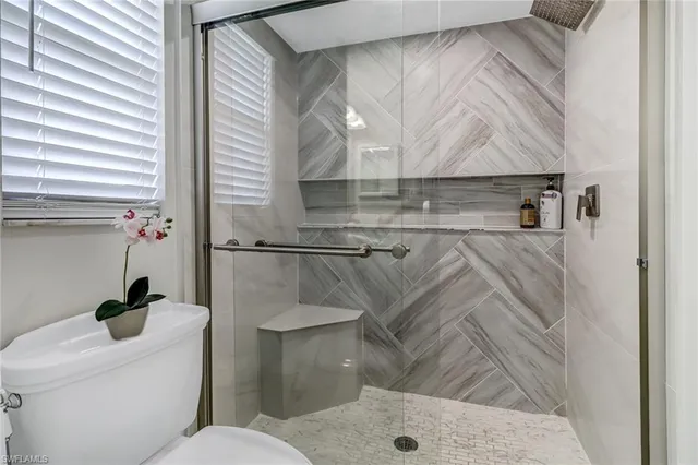 a bathroom with a toilet and a shower