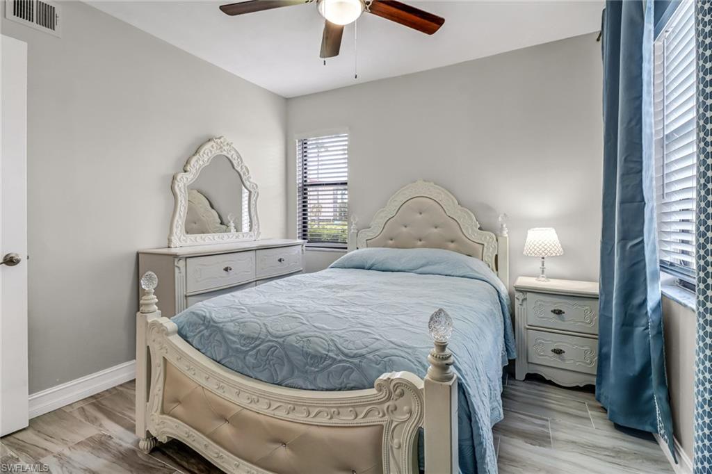4166 27th Court Southwest, Unit 104 Naples, FL 34116 - Photo 21 of 25 a bedroom with a bed and a mirror