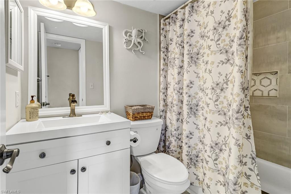 4166 27th Court Southwest, Unit 104 Naples, FL 34116 - Photo 22 of 25 a bathroom with a sink a toilet and a mirror