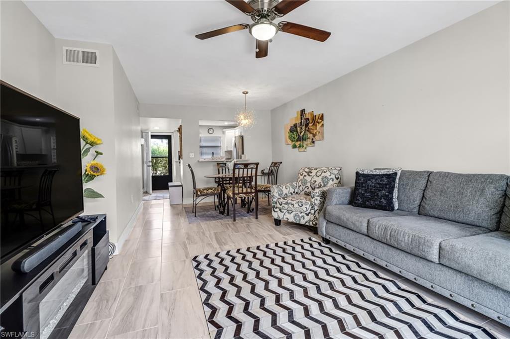 4166 27th Court Southwest, Unit 104 Naples, FL 34116 - Photo 7 of 25 a living room with furniture and a flat screen tv