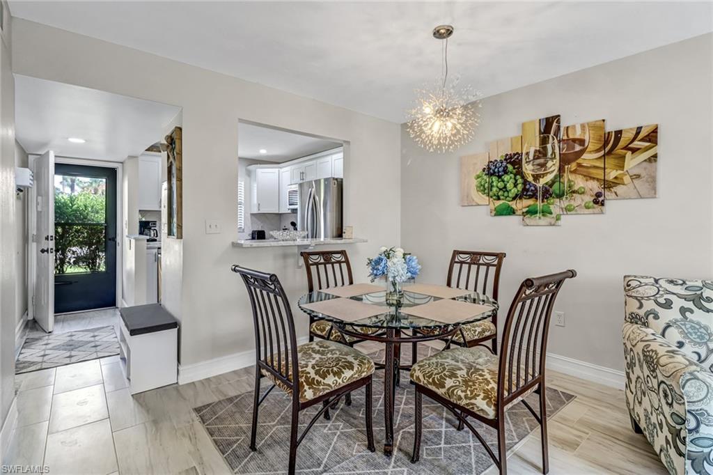 4166 27th Court Southwest, Unit 104 Naples, FL 34116 - Photo 8 of 25 a view of a dining room with furniture and chandelier