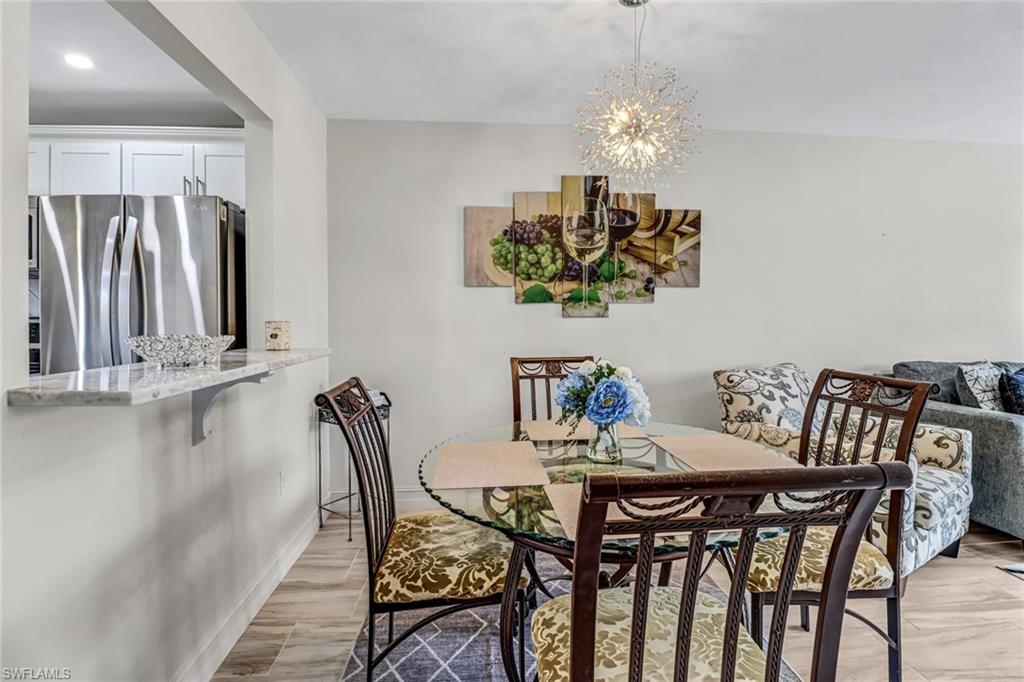 4166 27th Court Southwest, Unit 104 Naples, FL 34116 - Photo 9 of 25 a view of a dining room with furniture and chandelier