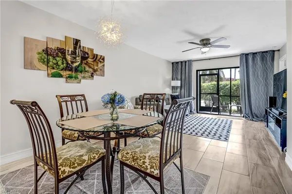 a view of a dining room with furniture a chandelier and wooden floor