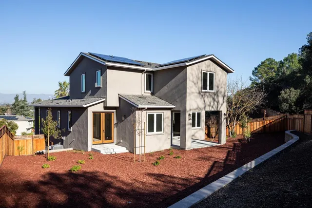 a view of a house with backyard and trees