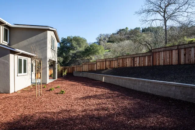 a view of house with backyard and trees