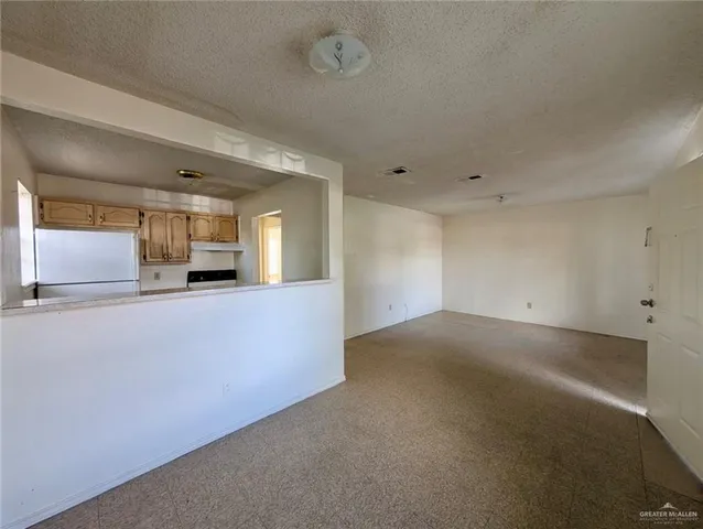 a view of a big room with wooden floor and windows