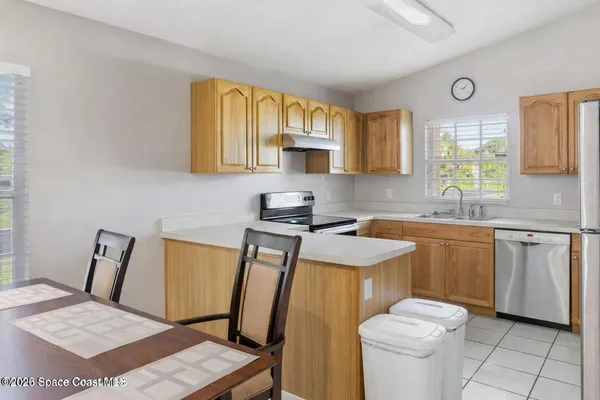 a kitchen with a sink a stove wooden floor and cabinets