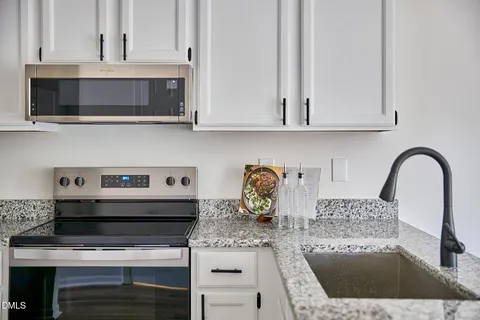 a kitchen with a stove and a white cabinets