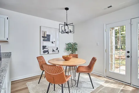 a dining room with furniture a chandelier and wooden floor