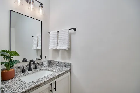 a bathroom with a granite countertop sink and a mirror