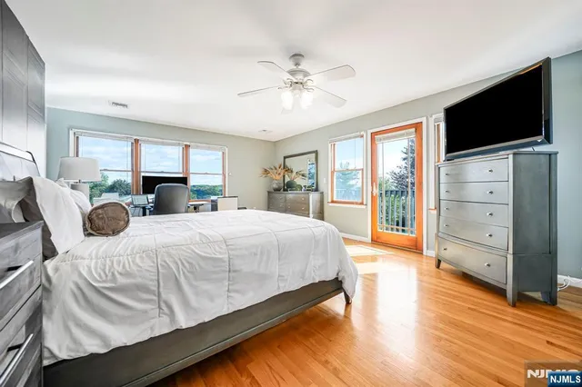 a spacious bedroom with a bed and a flat screen tv