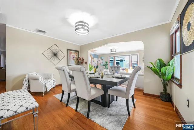 a view of a dining room with furniture a potted plant and wooden floor
