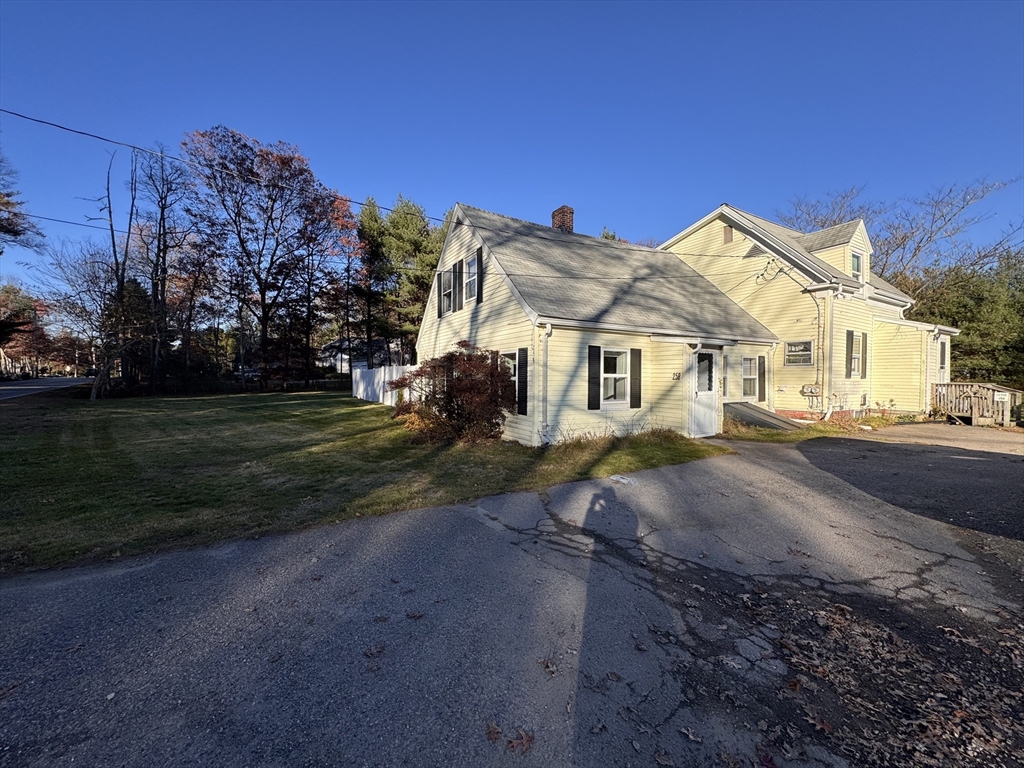 258 Walnut Street, Unit 1 Bridgewater, MA 02324 - Photo 2 of 19 a view of a white house next to a yard with road and plants