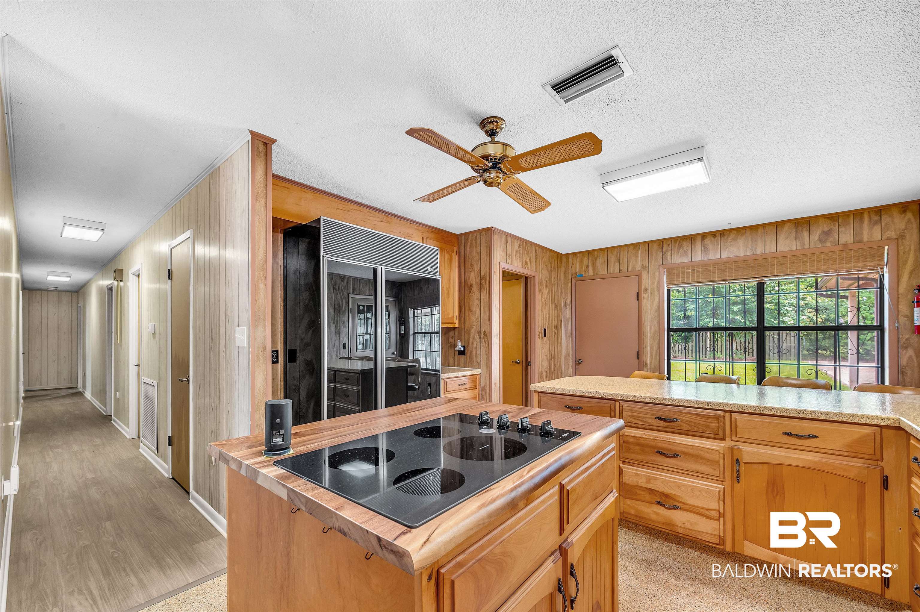 610 East Walker Avenue Foley, AL 36535 - Photo 20 of 38 Kitchen featuring black electric cooktop, built in refrigerator, light countertops, wood walls, and ceiling fan