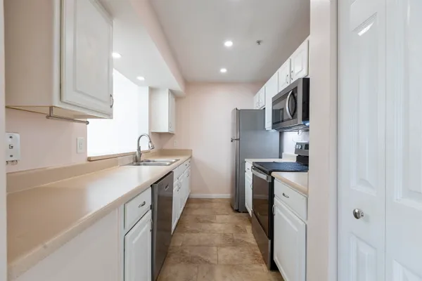 a kitchen with stainless steel appliances granite countertop a sink stove and microwave