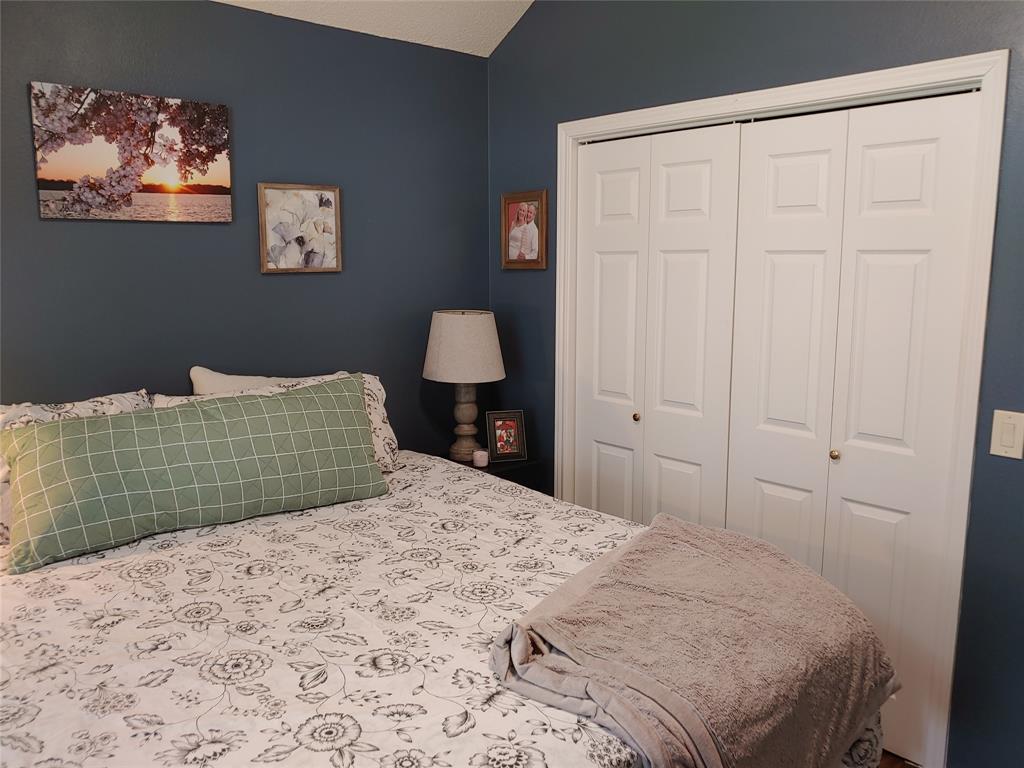 836 Airport Road Reno, TX 75462 - Photo 20 of 30 Room featuring a vaulted ceiling, deep blue wall paint, and white bi-fold closet doors