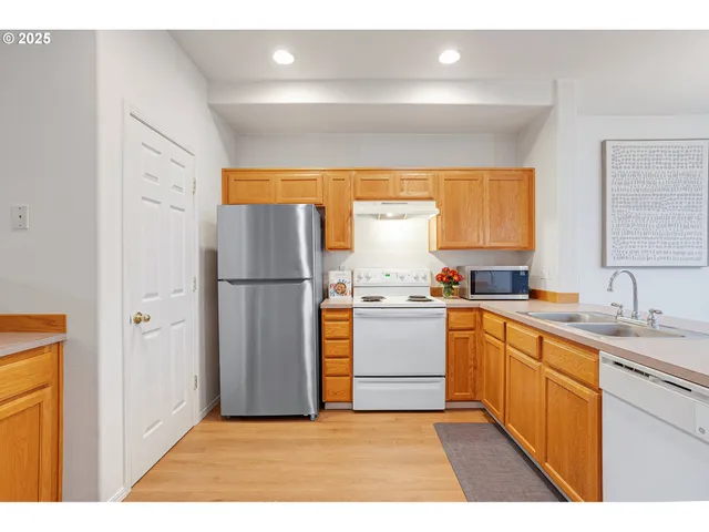 a kitchen with stainless steel appliances granite countertop a refrigerator and a sink