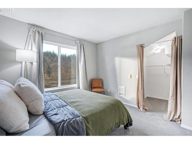 a bedroom with a bed and a large window