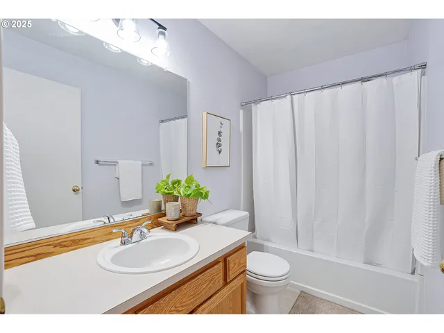 a bathroom with a granite countertop sink and a mirror with bathtub