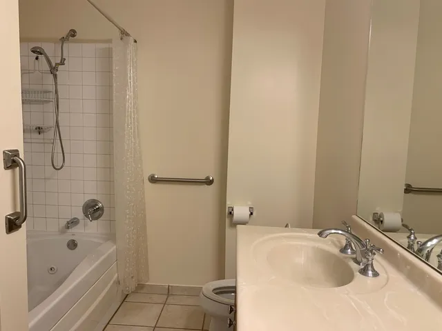 a bathroom with a tub sink vanity and shower