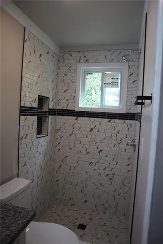 a bathroom with a toilet and a shower