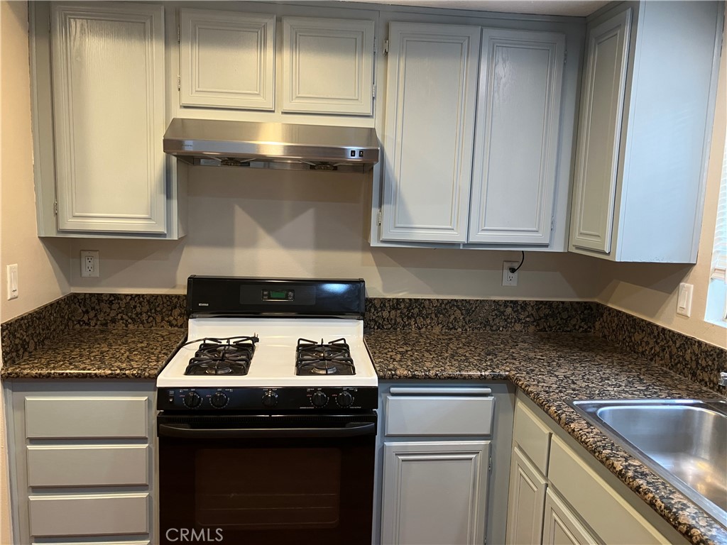 19933 Ralph Street Walnut, CA 91789 - Photo 27 of 77 a kitchen with granite countertop a stove sink and cabinets