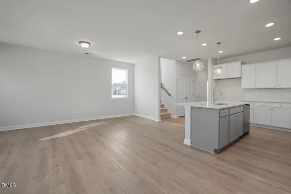 a large kitchen with stainless steel appliances granite countertop a large counter top a sink and a dishwasher